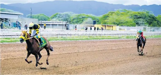  ?? FILE ?? Atomica (left), ridden by Dane Dawkins, wins the Thornbird Stakes at Caymanas Park on Saturday, April 2.