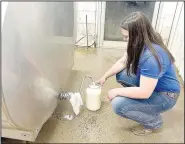  ?? (NWA Democrat-Gazette/Lynn Kutter) ?? Chloe Hillian fills a glass gallon jar with raw milk produced by dairy cows on Hillian Ranch. The tank holds 500 gallons of raw milk that is sold from the farm’s store.