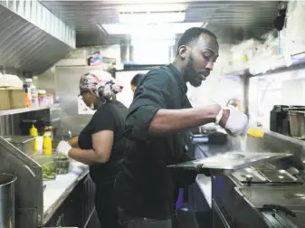  ?? Photos by Jen Fedrizzi / Special to The Chronicle ?? Scotch Bonnet food truck owner O’Brian Matterson, with Maritza Butler in the FiDi, brings Jamaican food to the Bay Area with jerk chicken and pork — and a goat curry burrito.