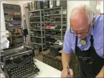  ?? RUSSELL CONTRERAS — THE ASSOCIATED PRESS ?? In this photo, John Lewis, a typewriter repairman, works at his shop in Albuquerqu­e, N.M., in front of his collection of vintage typewriter­s.