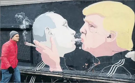  ?? ADAM BERRY / GETTY ?? Un hombre pasa junto a un grafiti de Vladímir Putin y Donald Trump en Vilnius, la capital de Lituania, en marzo del año pasado