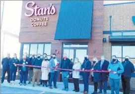  ?? BOB BONG/DAILY SOUTHTOWN ?? Owner Rich Labriola and Orland Park Mayor Keith Pekau, center, are surrounded by staffers and Orland Area Chamber of Commerce members as they cut the ribbon Dec. 3 to open the new Stan’s Donuts & Coffee shop in Orland Park.