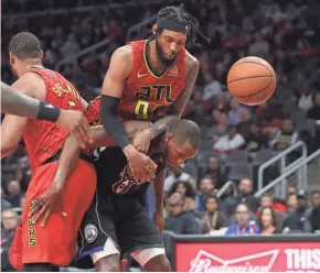  ?? JASON GETZ/USA TODAY ?? DeAndre’ Bembry goes for a ride on the back of Bucks forward Khris Middleton during a shot attempt. Bembry was called for a foul.