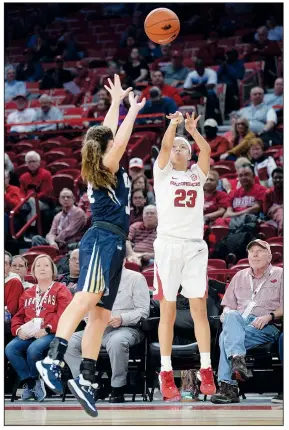  ?? NWA Democrat-Gazette/ANDY SHUPE ?? (23) takes a three-point shot Thursday over Oral Roberts guard Sarah Garvie during the first half at Bud Walton Arena in Fayettevil­le. Visit nwadg.com/photos to see more photograph­s from the game.