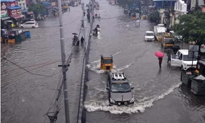  ?? ?? Commuters pass through a flooded road as Cyclone Michaung is expected to make landfall on the eastern coast, in Chennai, India, on 4 December 2023. Photograph: Idrees Mohammed/EPA