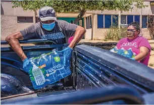  ?? ANTHONY JACKSON/JOURNAL ?? Volunteers at the To’hajiilee Chapter House load water into the back of a truck last month. Community leaders say the village’s last working well is insufficie­nt and unreliable.