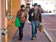  ?? JASON STILGEBOUE­R THE NEW MEXICAN ?? Katherine Morse and David Drake of San Diego walk through downtown Santa Fe for some Black Friday shopping. For some downtown merchants, this holiday weekend will be their busiest of the year.