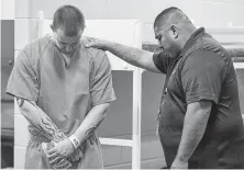  ??  ?? Army veteran Austin Everett and Harris County Sheriff's Office Chaplain Eduardo Perez pray. Brothers in Arms was started by the Jail Chaplaincy Department.