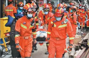  ?? GUO LILIANG / FOR CHINA DAILY ?? Rescuers transport a survivor who was removed on Sunday from the debris of an eight-story building that collapsed in Changsha, Hunan province, on Friday. Seven survivors had been rescued as of Sunday evening, and 16 other people were believed to be trapped inside.