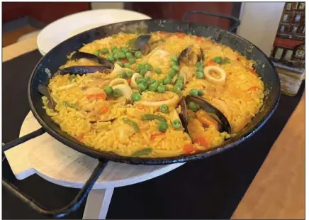  ?? (Arkansas Democrat-Gazette/Eric E. Harrison) ?? Calamari, shrimp, clams, mussels and chicken, along with plentiful rice, made up the Friday seafood paella special at Mi Paella.