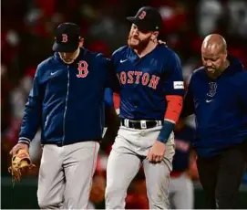  ?? JOHN MCCOY/GETTY IMAGES ?? A pained Trevor Story walked off the field with help from manager Alex Cora (left) and trainer Brandon Henry.