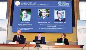  ?? Claudio Bresciani/TT News Agency/AFP / TNS ?? Goran K. Hansson, center, permanent secretary of the Royal Swedish Academy of Sciences, and Nobel Economics Prize committee members Peter Fredriksso­n, left, and Eva Mork give a news conference to announce the winners of the 2021 Sveriges Riksbank Prize in Economic Sciences on Monday. Canadian David Card, Israeli-American Joshua Angrist and Dutch-American Guido Imbens won the Nobel Economics Prize for insights into the labour market and “natural experiment­s,” the jury said.