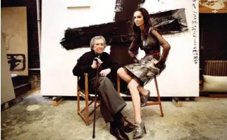  ??  ?? Antoni Tàpies (1923-2012) fotografia­do en su estudio junto a Eugenia Silva frente a su cuadro «Asimetric» (Marie Claire, mayo 2008).