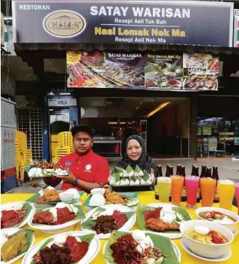  ??  ?? Saddam dan Nek Ma menunjukka­n sebahagian menu popular yang menjadi pilihan pelanggan.