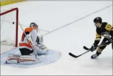  ?? GENE J. PUSKAR — THE ASSOCIATED PRESS ?? Penguins forward Bryan Rust deflects the puck past Flyers goalie Petr Mrazek for the overtime game-winning goal in a 5-4 decision for the Pens Saturday.
