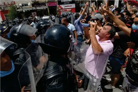  ??  ?? Tunisian security forces face off with anti - government demonstrat­ors in Tunis (AFP/Getty)