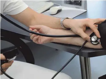  ?? FOTO: BERND WEIAÜBROD/DPA ?? Ein Arzt misst bei einer Patientin den Blutdruck: Angestellt­e müssen ab dem Jahr 2021 knapp 2000 Euro mehr im Jahr verdienen, um Leistungen einer privaten Krankenver­sicherung in Anspruch nehmen zu können.
