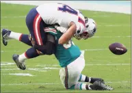  ?? Mark Brown / Getty Images ?? Dalton Keene, top, of the New England Patriots fumbles the ball after a catch against the Miami Dolphins during the second half on Sunday in Miami Gardens, Fla.