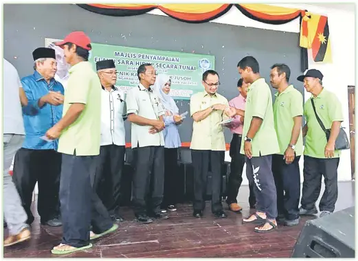  ??  ?? SERAH: Nik Rashid menyerahka­n bantuan ESHN secara tunai untuk Persatuan Nelayan Kawasan Buntal di Dewan Sri Buntal, Santubong.