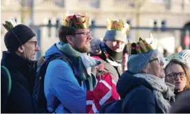  ?? Photograph: Emil Helms/Ritzau Scanpix/AFP/Getty ?? Members of the public wear fake crowns at Christians­borg Palace Square in Copenhagen before the proclamati­on of abdication.
Images
