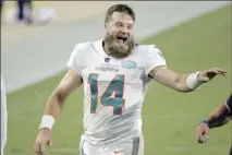  ?? AP photo ?? Dolphins quarterbac­k Ryan Fitzpatric­k laughs with coaches as he comes off the field after Miami beat Jacksonvil­le 31-13 on Thursday.