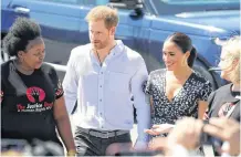  ?? MIKE HUTCHINGS REUTERS ?? The Duke and Duchess of Sussex, Prince Harry and his wife, Meghan, are welcomed to a Justice Desk initiative in Nyanga township, on the first day of their African tour in Cape Town, South Africa, Sept 23.