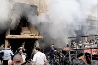  ?? AP/SANA ?? Syrians gather in front of a building destroyed by a car bomb Monday in Damascus in this photo from the official Syrian news agency.