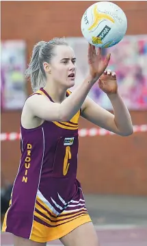  ?? Photograph­s by CRAIG JOHNSON. ?? Left: Drouin centre April Bethune pushes a pass against Leongatha on Saturday.
Leongatha proved too strong, winning 50-33.
Drouin remains in fifth place on the ladder in a tight battle for finals.