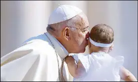  ?? REUTERS ?? Pope Francis kisses a baby during his weekly general audience in St. Peter’s Square at the Vatican on Monday.