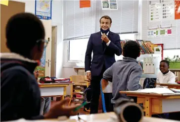  ??  ?? « C’est qui ? » Le 5 mai, Emmanuel Macron, venu soutenir les enseignant­s en vue du déconfinem­ent, fait tomber son masque « grand public » devant des élèves de l’école élémentair­e Pierre-deRonsard, à Poissy, qui ne l’avaient pas reconnu.