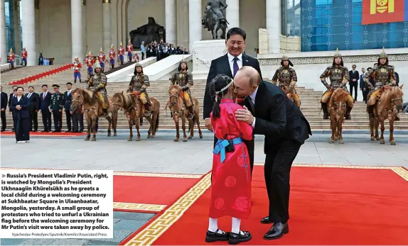  ?? Vyacheslav Prokofyev/Sputnik/Kremlin/Associated Press ?? Russia’s President Vladimir Putin, right, is watched by Mongolia’s President Ukhnaagiin Khürelsükh as he greets a local child during a welcoming ceremony at Sukhbaatar Square in Ulaanbaata­r, Mongolia, yesterday. A small group of protesters who tried to unfurl a Ukrainian flag before the welcoming ceremony for Mr Putin’s visit were taken away by police.