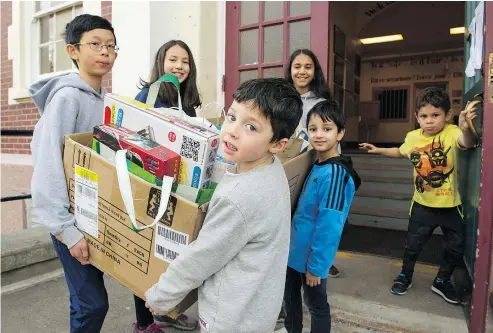  ?? GERRY KAHRMANN/PNG ?? Grade 7 students Christophe­r Shuen, left, Dana Edamura and Helen Mihlar get help from kindergart­en students Ellie McQueen, left, Herschel Sharma and Sebastian Gonzalez carrying items for the fundraiser.