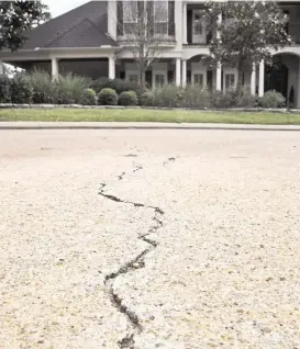  ?? Houston Chronicle file ?? A crack from a surface fault line runs toward Gordy Bunch’s Carlton Woods home in The Woodlands. Once worth $1.5 million, Bunch’s house is now valued at $200,000, according to Montgomery Central Appraisal District records.