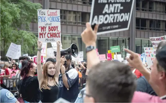  ?? PAT NABONG/SUN-TIMES ?? An abortion rights advocate holds a sign in front of counterpro­testers during the “Defend Abortion Access” rally earlier this month in the Loop.