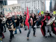  ?? CP PHOTO DARRYL DYCK ?? Alex Spence, centre, who is originally from Haida Gwaii, beats a drum and sings Tuesday during a march in Vancouver in support of pipeline protesters in northweste­rn B.C. Fourteen people were taken into custody Monday at a blockade southwest of Houston, B.C., where members of the Gidimt’en clan of the Wet’suwet’en First Nation had set up a camp to control access to a pipeline project across their territory.