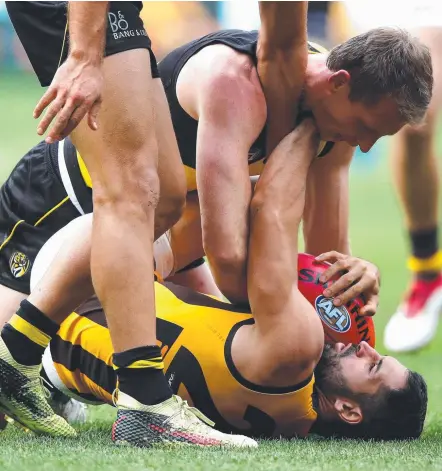  ?? Picture: GETTY IMAGES ?? Richmond’s Dylan Grimes comes to grips with Hawks forward Paul Puopolo after the controvers­ial free kick.