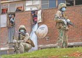  ?? (AP/Jerome Delay) ?? South African National Defense Forces patrol the Men’s Hostel in the densely populated Alexandra township east of Johannesbu­rg, on March 28, 2020, enforcing a strict lockdown in an effort to control the spread of the coronaviru­s. Photograph­er Jerome Delay said the scene reminded him of South Africa before apartheid ended in 1994, with the army raiding the hostel not looking for guns but enforcing a strict lockdown that included a ban on the use of cigarettes and alcohol. He says he still hears the men, packed six to a room, shouting down the halls: “If we can’t go out and can’t work, we can’t eat.”