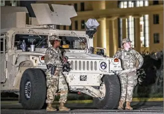  ?? JOHN SPINK / JSPINK@AJC.COM ?? National Guard troops are posted on Trinity Avenue in downtown Atlanta on Wednesday. The governor ordered 1,000 troops to deploy to government sites across the city over the mayor’s vocal objection.
