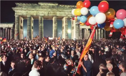  ??  ?? A crowd celebrates German reunificat­ion on 2 October 1990 at the Brandenbur­g Gate in Berlin. Photograph: Fotoreport/DPA/PA Images