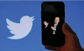  ?? (AFP) ?? In this file photo taken on October 4, a phone screen displays a photo of Elon Musk with the Twitter logo shown in the background in Washington, DC