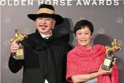  ?? . — AFP photos ?? Taiwanese actress Sylvia Chang and Actor Anthony Wong of Hong Kong pose for pictures after winning the Best Leading Actress award with the film “A Light Never Goes Out” and the Best Leading Actor award with film “The Sunny Side of the Street” at the 59th Golden Horse Film Awards in Taipei