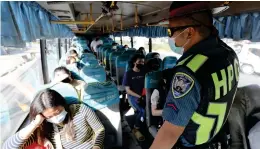  ?? (JOEY O. RAZON/PNA) ?? VAX CHECK. An officer of the Highway Patrol Group (HPG) inspects vaccinatio­n cards of passengers of a public utility bus along Marcos Highway in Antipolo City, Rizal en route to Metro Manila on Wednesday (Jan. 12, 2022).