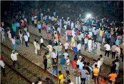  ??  ?? People gather near the site of a train accident at Joda Phatak in Amritsar on Friday.