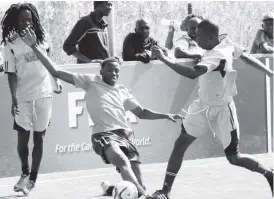  ??  ?? Fox player Nqobile Moyo tackles Bulawayo Artists’ Shylock Ndlovu while his partner Ralph Malingwa keeps a close eye in a match played in Gwabalanda yesterday