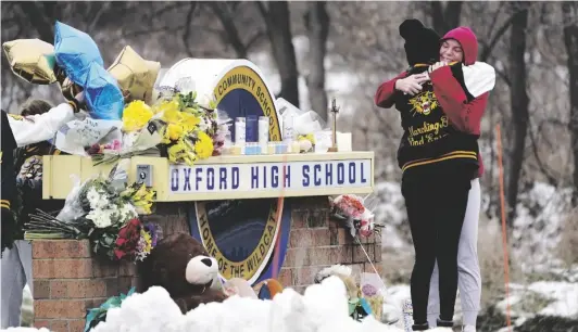  ?? AP PHOTO/PAUL SANCYA ?? Students hug at a memorial at Oxford High School in Oxford, Mich., Dec. 1.