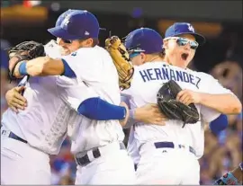  ?? Wally Skalij Los Angeles Times ?? DODGERS, from left, Manny Machado, Chris Taylor, Enrique Hernandez and Joc Pederson hug after beating Colorado in Monday’s 163rd game to win their division.