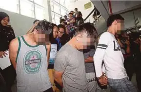  ?? INTAN NUR ELLIANA ZAKARIA
PIC BY ?? Police officers escorting the three suspects involved in the JJ Poor To Rich scheme at the magistrate’s court in Klang yesterday.