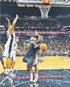  ??  ?? Miami Heat forward LeBron James (right) drives to the basket against San Antonio Spurs forward Boris Diaw (left) in game two of the 2014 NBA Finals at AT&T Center. — USA TODAY Sports photo
