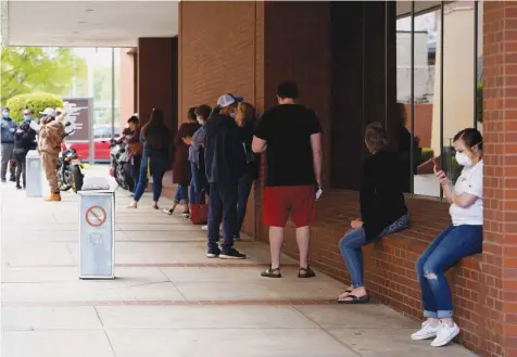  ?? — Reuters ?? People who lost their jobs wait in line to file for unemployme­nt at an Arkansas Workforce Center in Fort Smith, Arkansas, US.