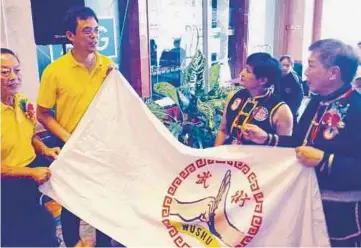  ??  ?? TAN (dua dari kiri) menaikkan bendera Persekutua­n Nanyang Wushu Sarawak bagi merasmikan Kejohanan Pesta Kung Fu Nanyang Wushu ke-28, di sini, semalam.